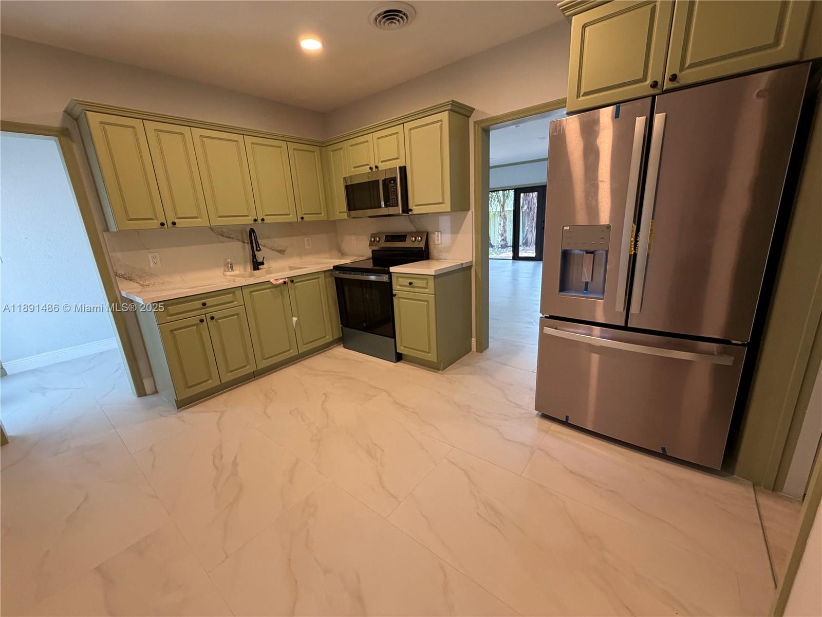 2120 Southwest 84th Avenue Miami, FL 33155 - Photo 11 of 26 a kitchen with stainless steel appliances granite countertop a refrigerator sink and microwave