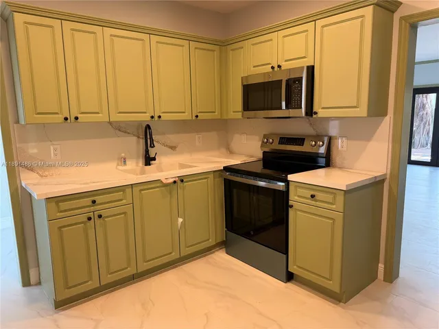 a kitchen with stainless steel appliances granite countertop a sink stove and microwave