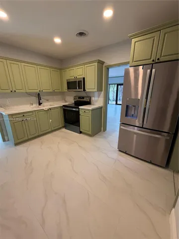 a kitchen with stainless steel appliances granite countertop a refrigerator a sink a stove a microwave a counter top and cabinets