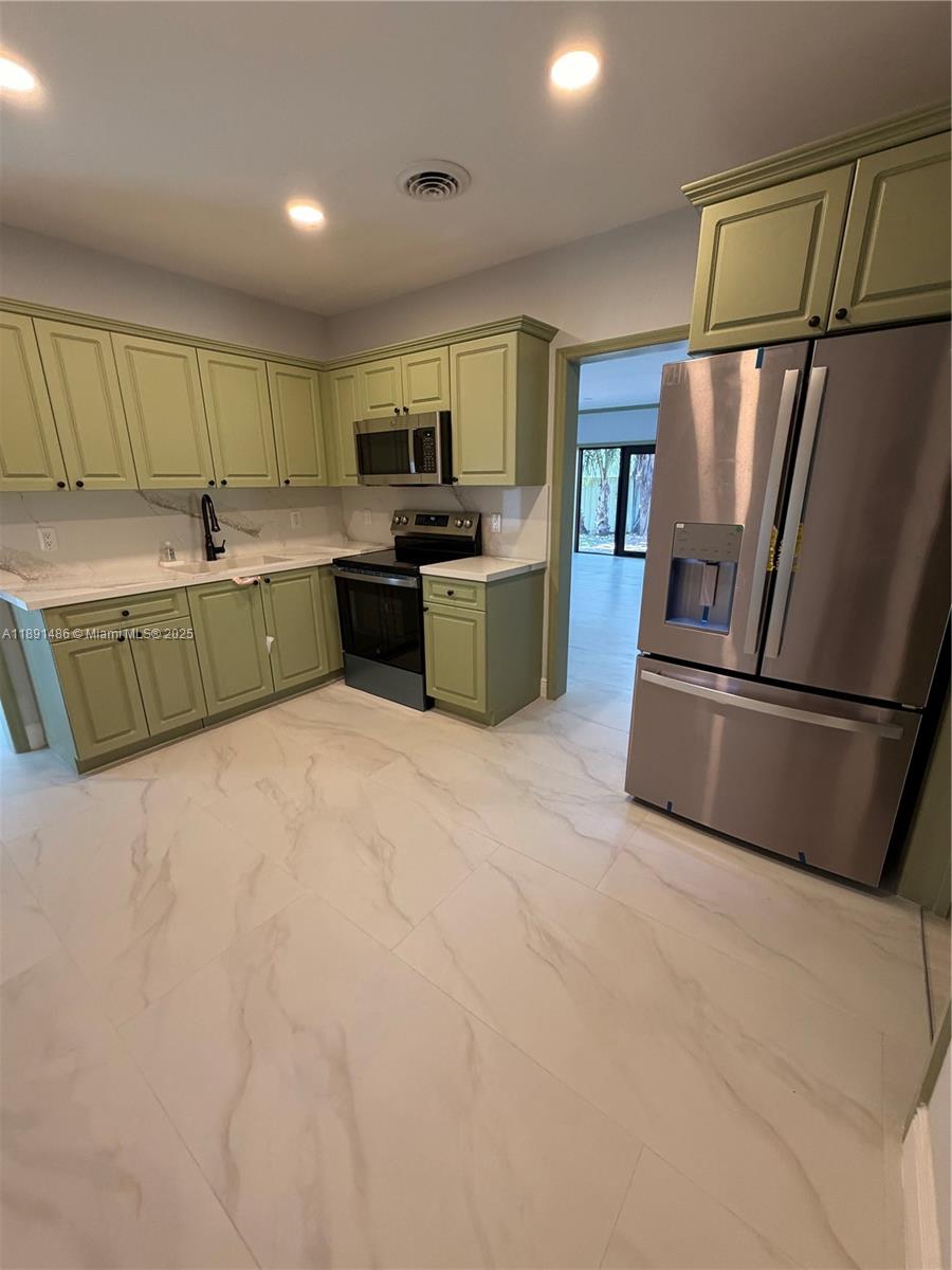 2120 Southwest 84th Avenue Miami, FL 33155 - Photo 16 of 26 a kitchen with stainless steel appliances granite countertop a refrigerator a sink a stove a microwave a counter top and cabinets