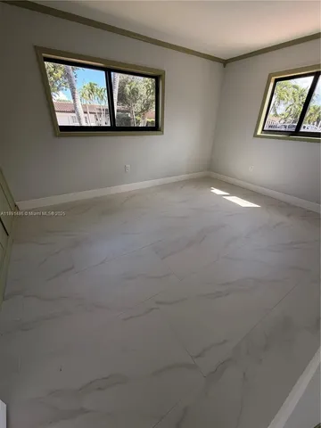 an empty room with windows and fireplace