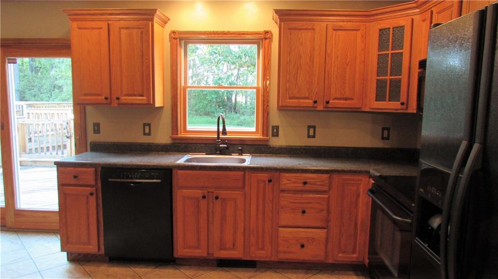 Oak kitchen includes microwave, electric stove, refrigerator and pantry cupboard