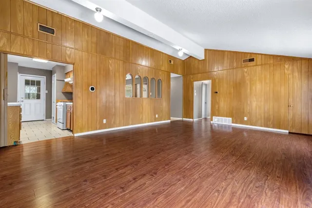 a view of an empty room with wooden floor