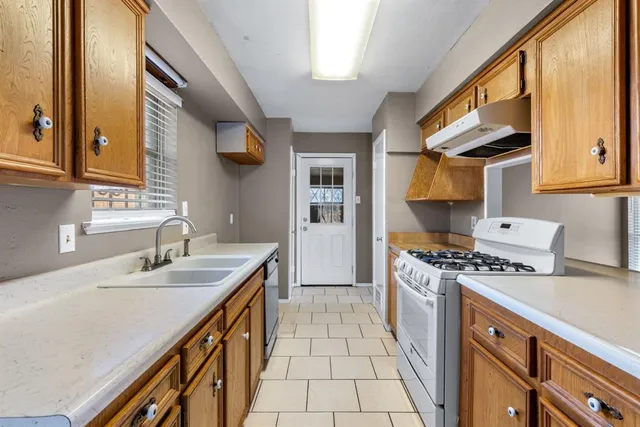 a kitchen with a stove a sink and a refrigerator