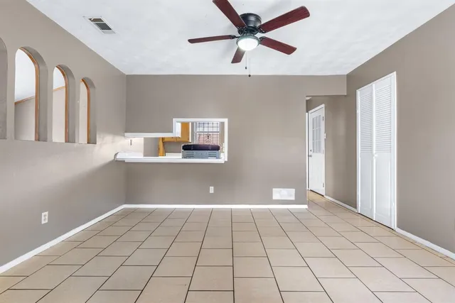 a view of a livingroom with a ceiling fan and window