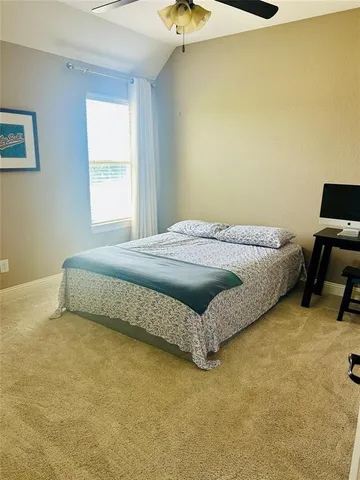 a bed sitting in a bedroom next to a window