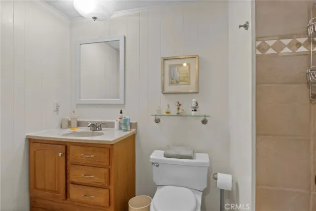 a bathroom with a toilet sink vanity granite and mirror