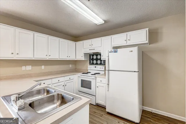 a view of a kitchen with sink washer and refrigerator
