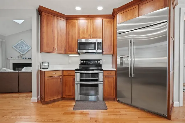 a kitchen with stainless steel appliances granite countertop wooden cabinets a stove top oven a sink and dishwasher