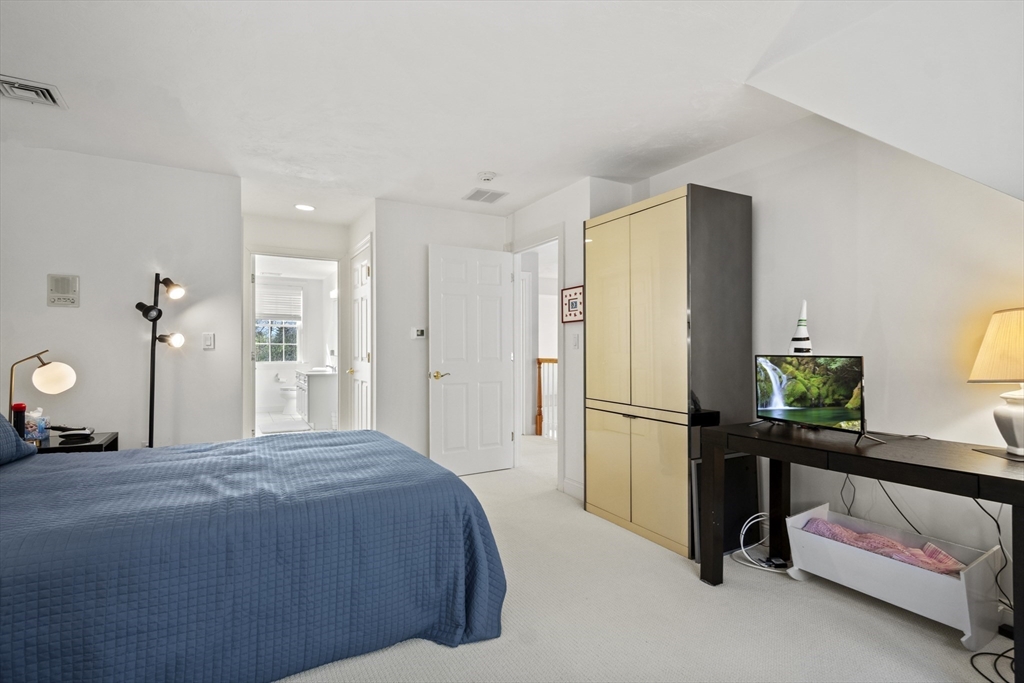 36 Caldwell Farm Road, Unit 36 Newbury, MA 01922 - Photo 25 of 42 a bedroom with a bed and cabinets