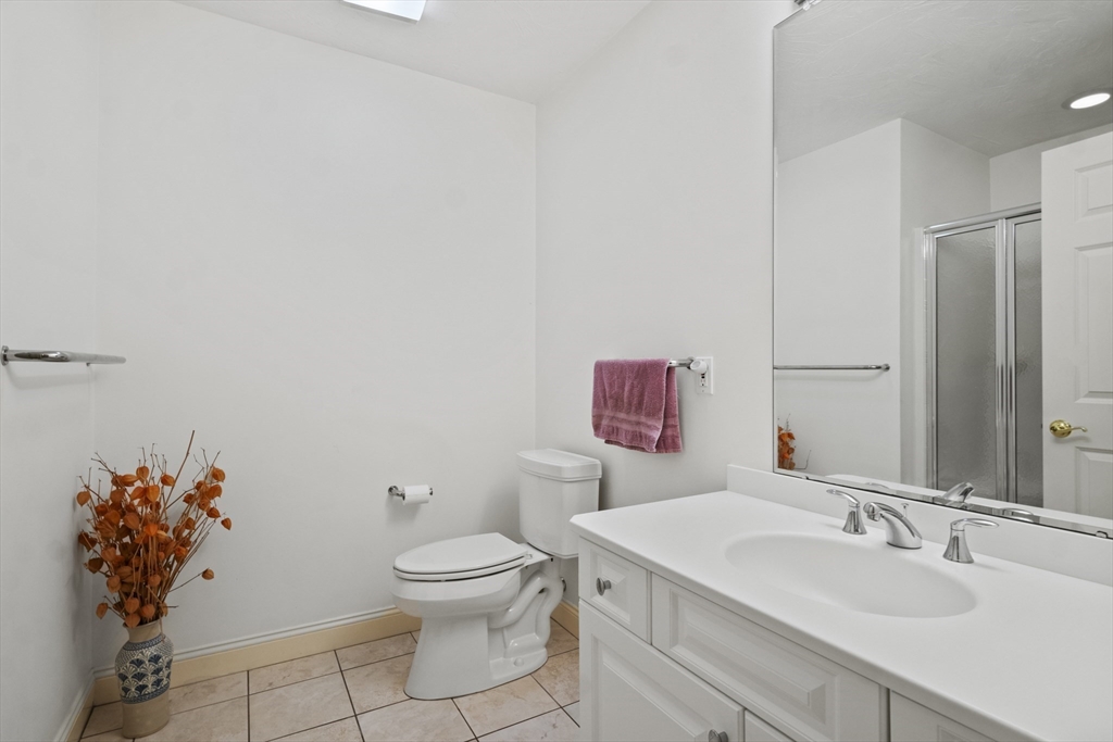 36 Caldwell Farm Road, Unit 36 Newbury, MA 01922 - Photo 32 of 42 a bathroom with a granite countertop toilet sink and mirror
