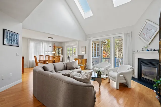 a kitchen with stainless steel appliances granite countertop a stove top oven a sink dishwasher a dining table and chairs with wooden floor