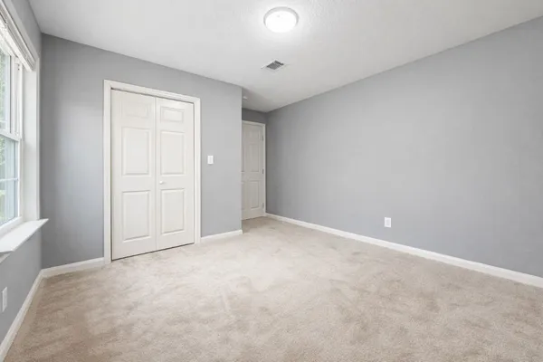an empty room with windows and closet