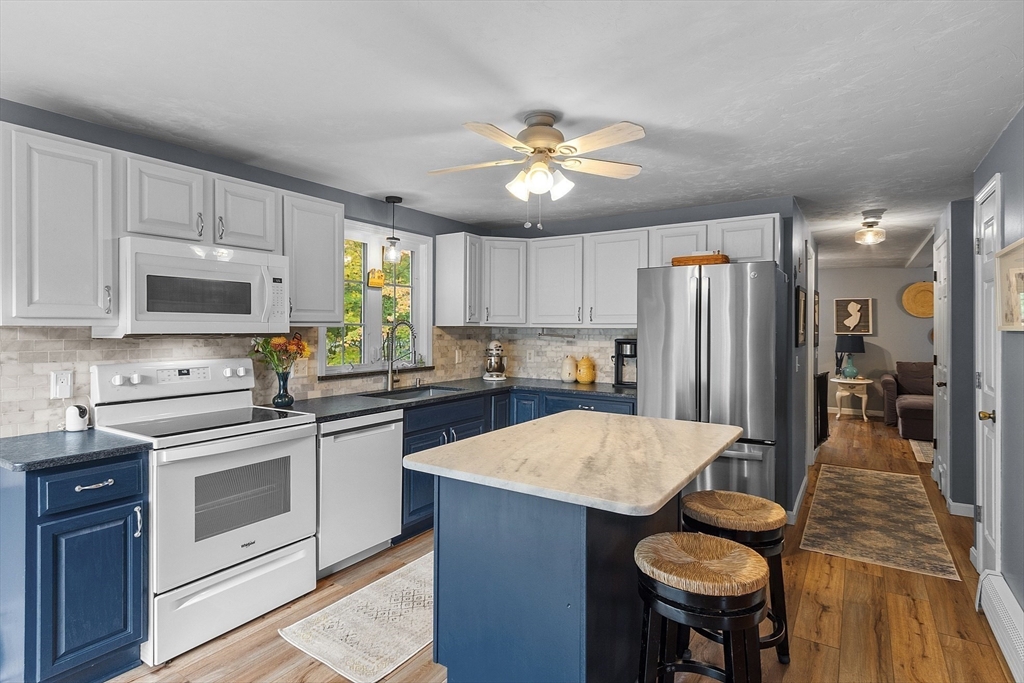 2 White Road Holland, MA 01521 - Photo 17 of 40 a kitchen with stainless steel appliances a stove a sink dishwasher a refrigerator with a dining table and chairs