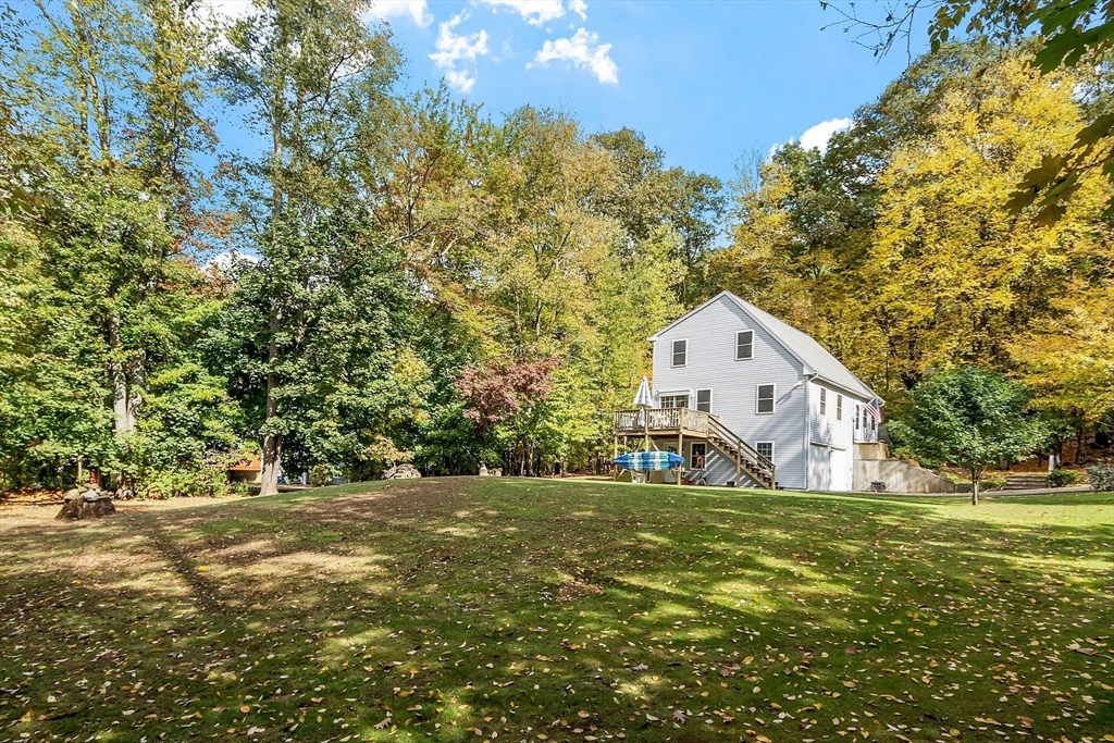 2 White Road Holland, MA 01521 - Photo 6 of 40 a backyard of a house with large trees and parked