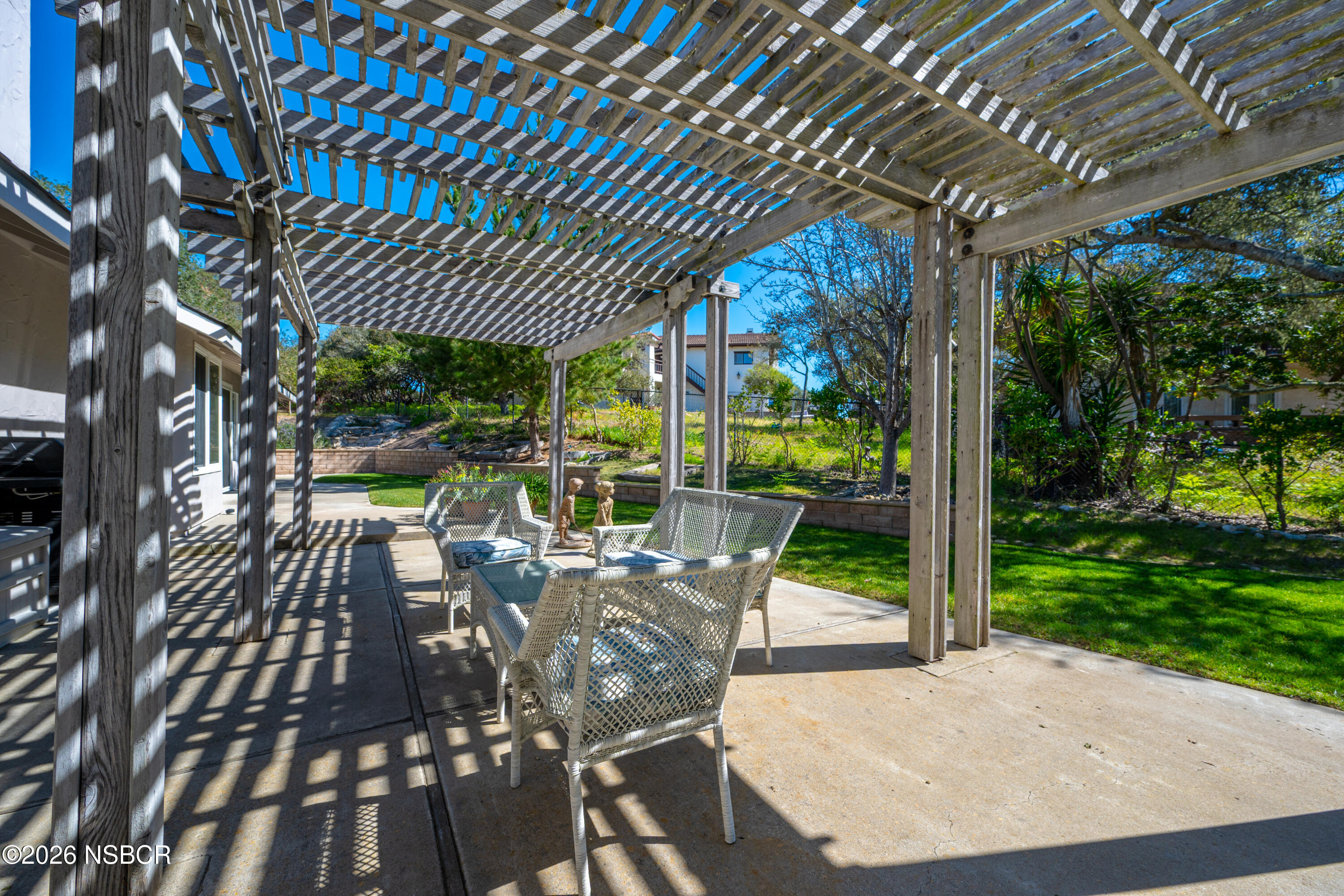 4473 Greenbrier Road Lompoc, CA 93436 - Photo 37 of 54 a view of a patio with table and chairs potted plants with large tree