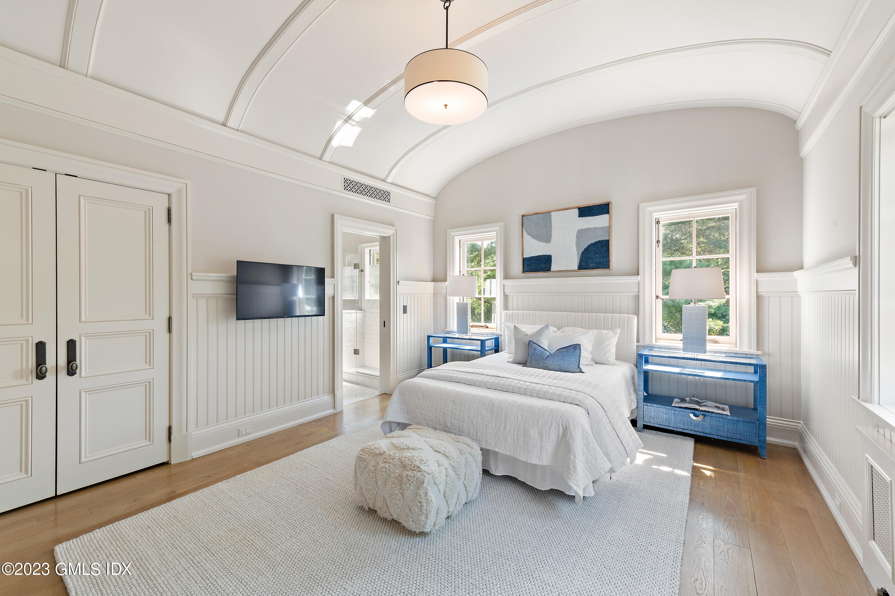 2 Martin Dale Greenwich, CT 06830 - Photo 26 of 53 a bedroom with a bed a chandelier and a flat tv screen