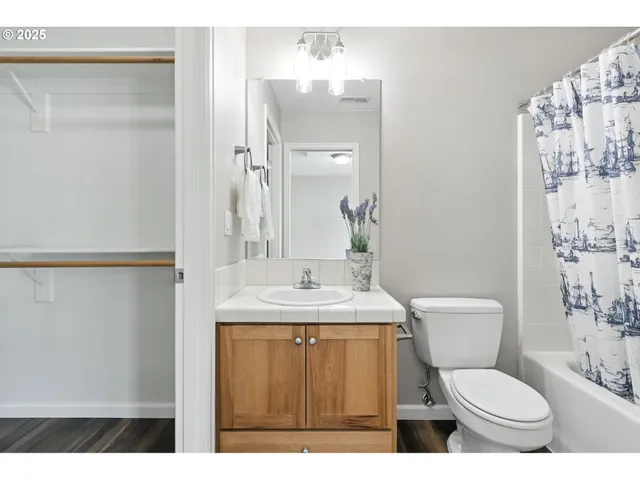 a bathroom with a granite countertop toilet sink and mirror