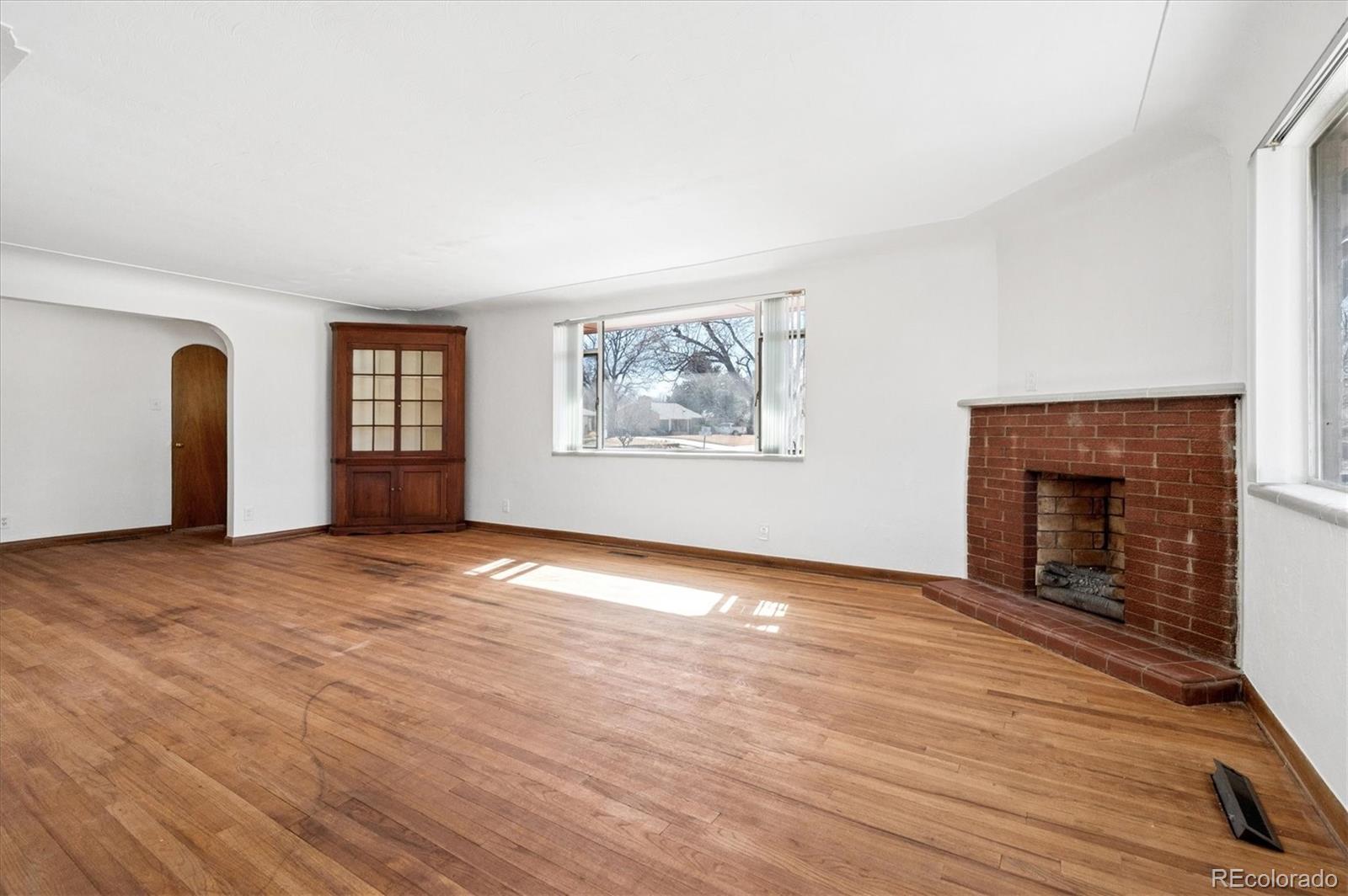 7505 West 47th Avenue Wheat Ridge, CO 80033 - Photo 11 of 35 an empty room with windows and fireplace