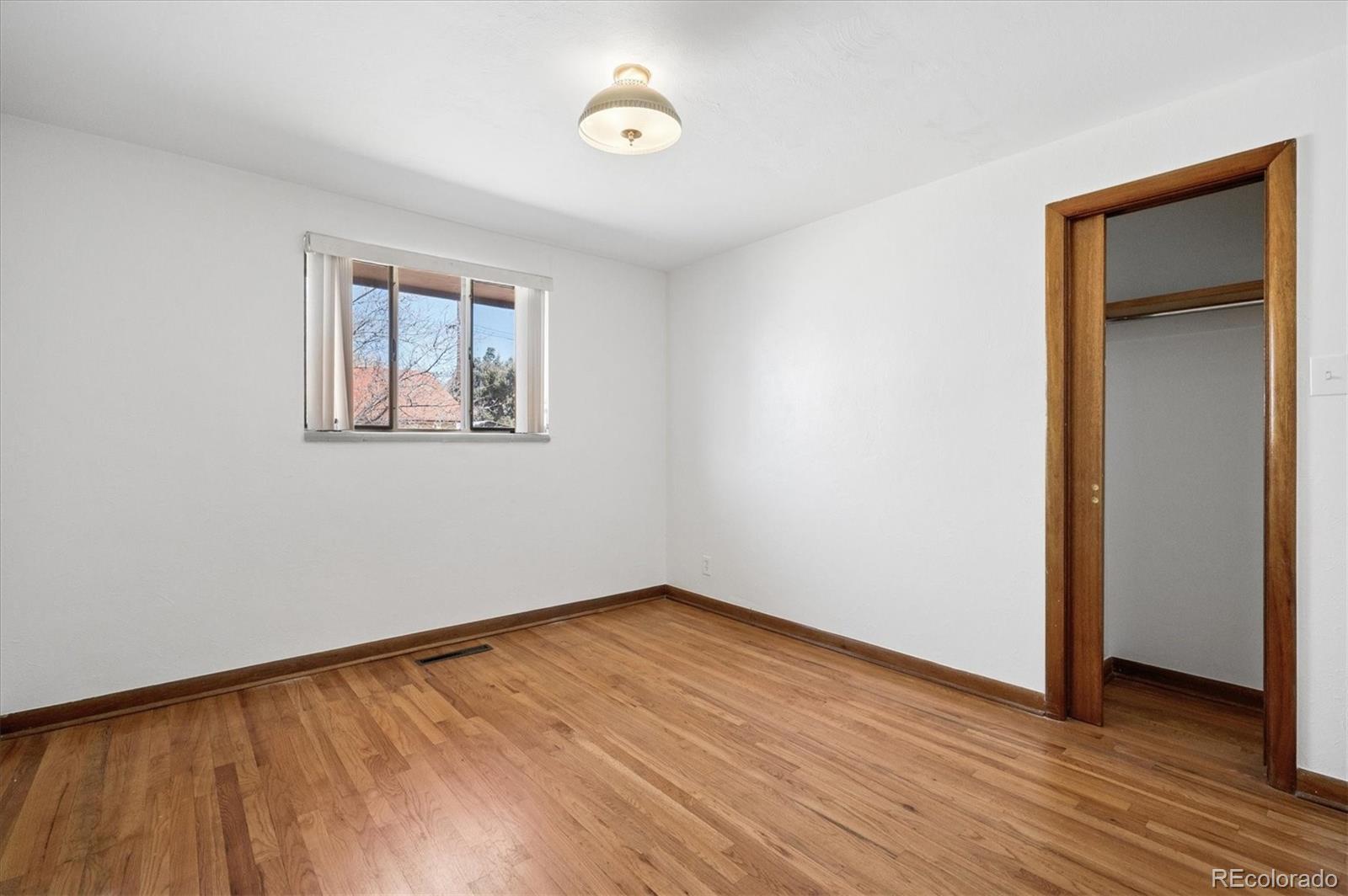 7505 West 47th Avenue Wheat Ridge, CO 80033 - Photo 21 of 35 an empty room with wooden floor and windows