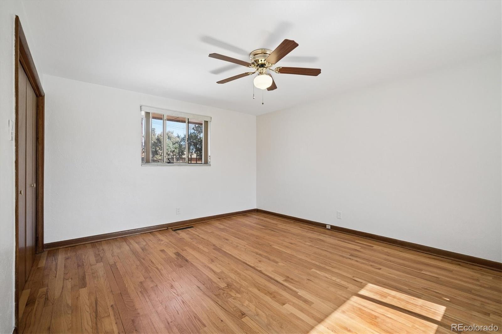 7505 West 47th Avenue Wheat Ridge, CO 80033 - Photo 22 of 35 an empty room with wooden floor and windows