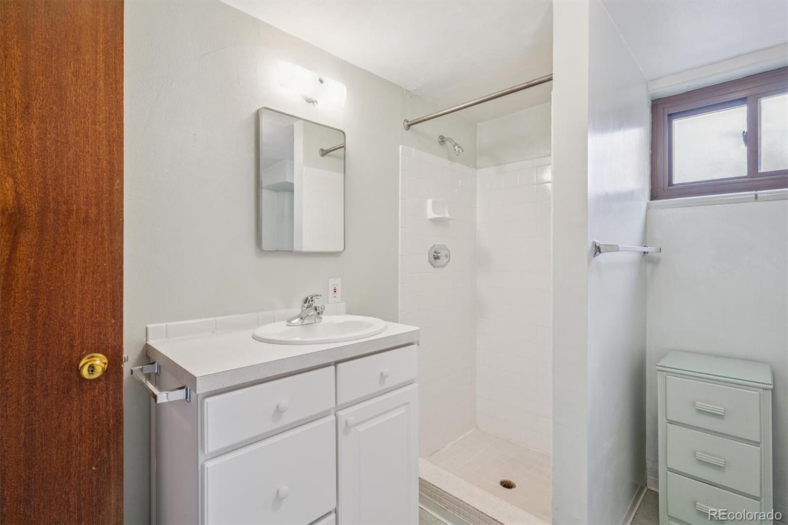 7505 West 47th Avenue Wheat Ridge, CO 80033 - Photo 29 of 35 a bathroom with a sink mirror and shower
