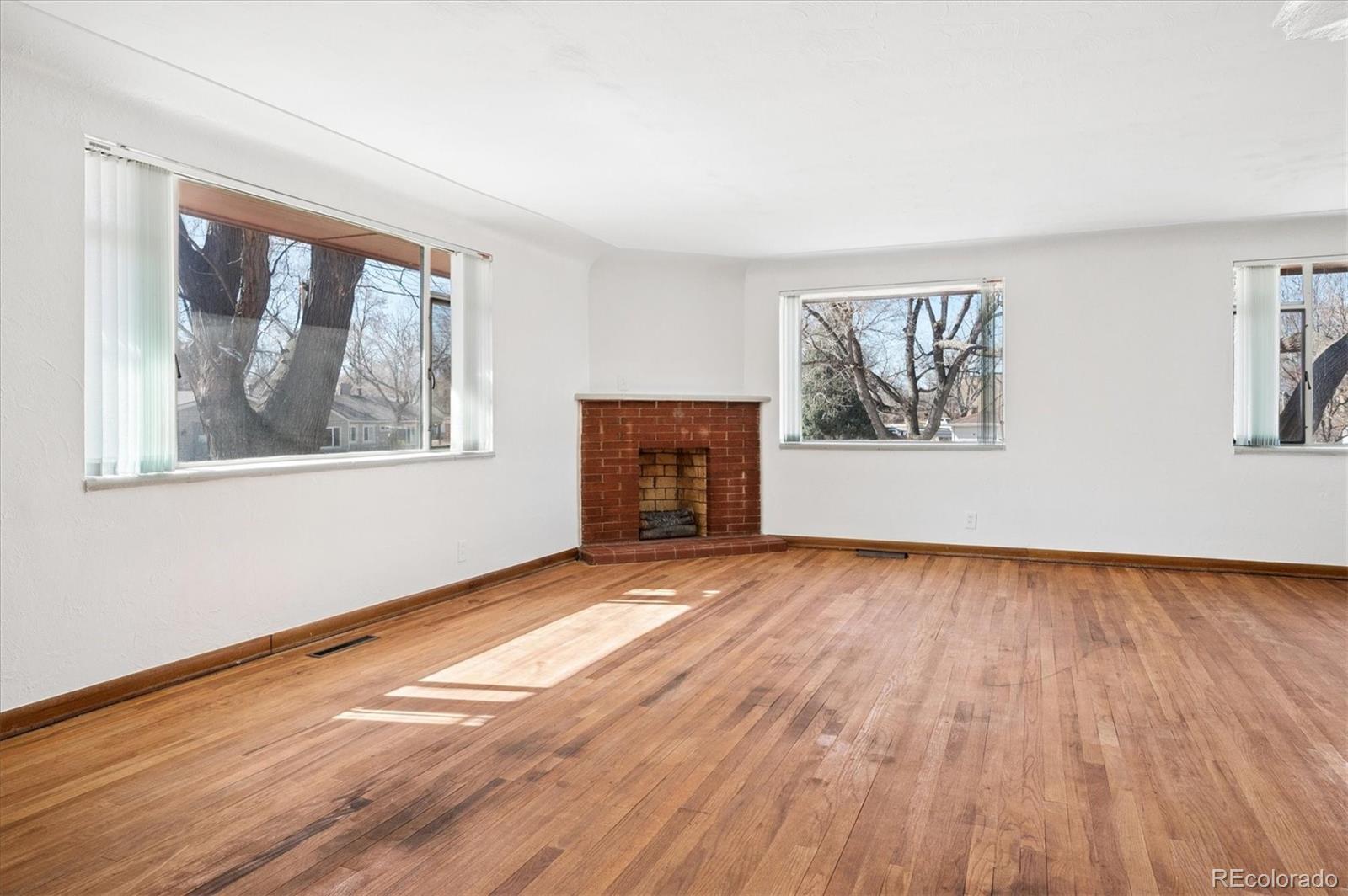 7505 West 47th Avenue Wheat Ridge, CO 80033 - Photo 9 of 35 a view of an empty room with wooden floor and a window