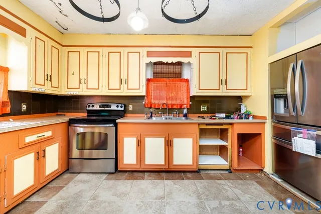 a kitchen with stainless steel appliances granite countertop a stove a sink and a refrigerator