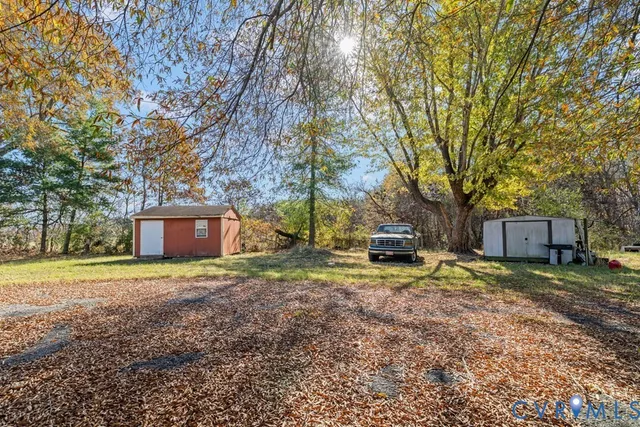 a view of a house with backyard and tree
