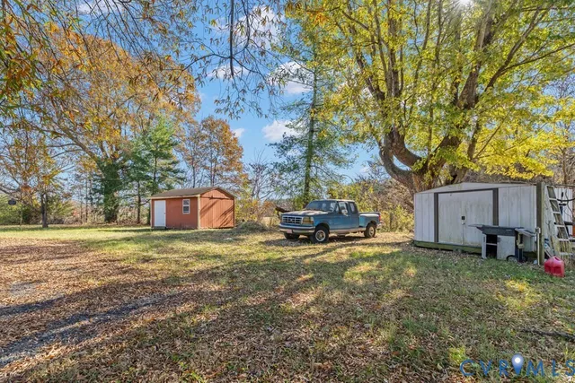 a view of a house with backyard and trees
