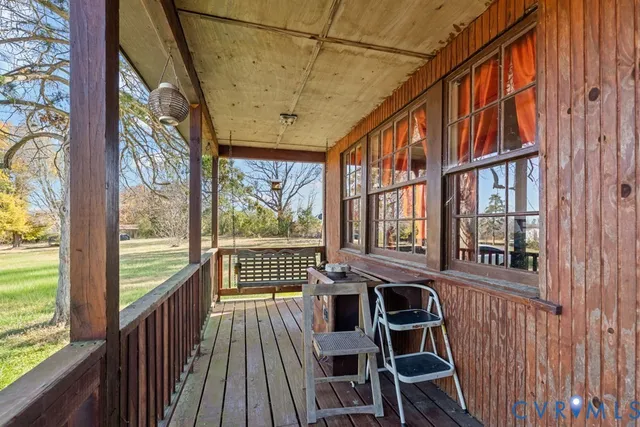 a view of a balcony with chairs and wooden floor