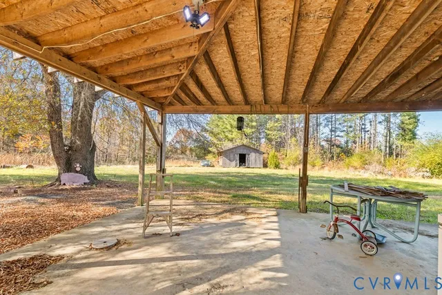 a view of a room with table and chairs under an umbrella