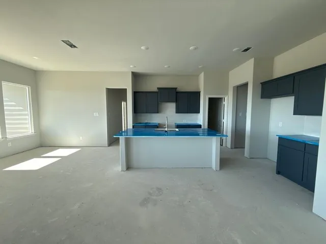 a large kitchen with stainless steel appliances kitchen island a large counter top and a sink