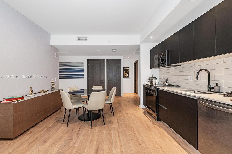 398 Northeast 5th Street, Unit 2418 Miami, FL 33132 - Photo 11 of 34 a dining room with a sink and a stove top oven