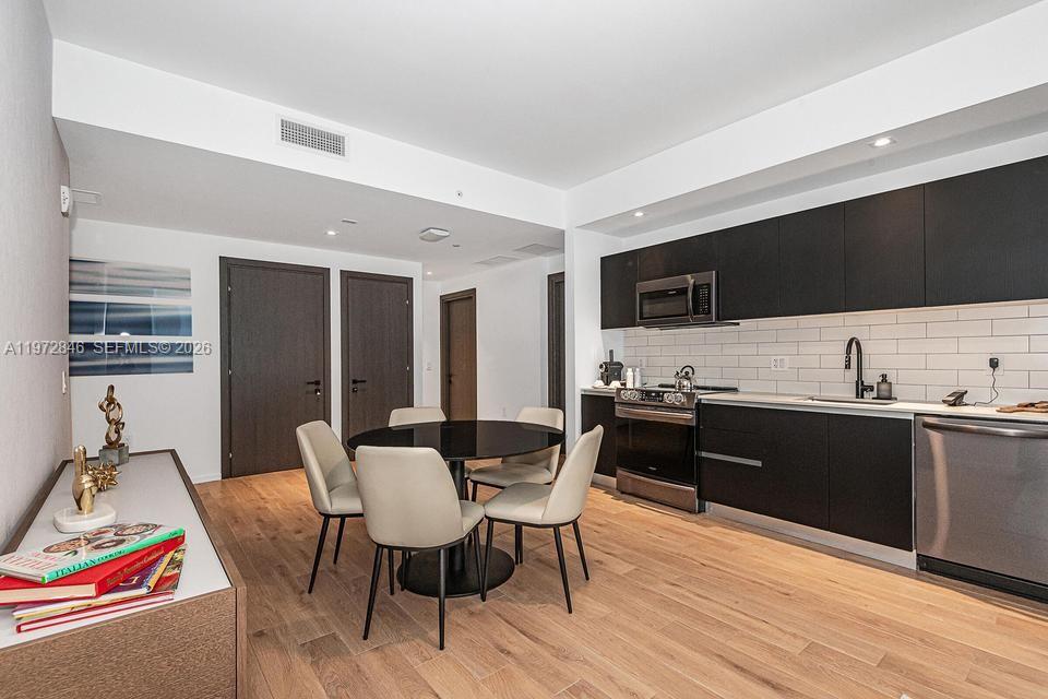 398 Northeast 5th Street, Unit 2418 Miami, FL 33132 - Photo 12 of 34 a view of a dining room with furniture and wooden floor