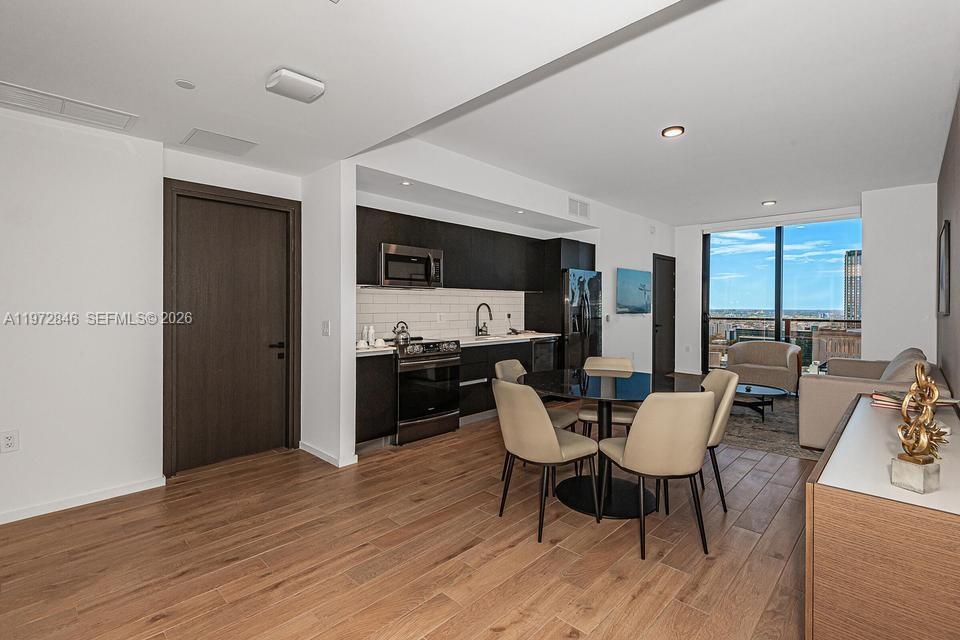 398 Northeast 5th Street, Unit 2418 Miami, FL 33132 - Photo 2 of 34 a view of a dining room with furniture window and wooden floor