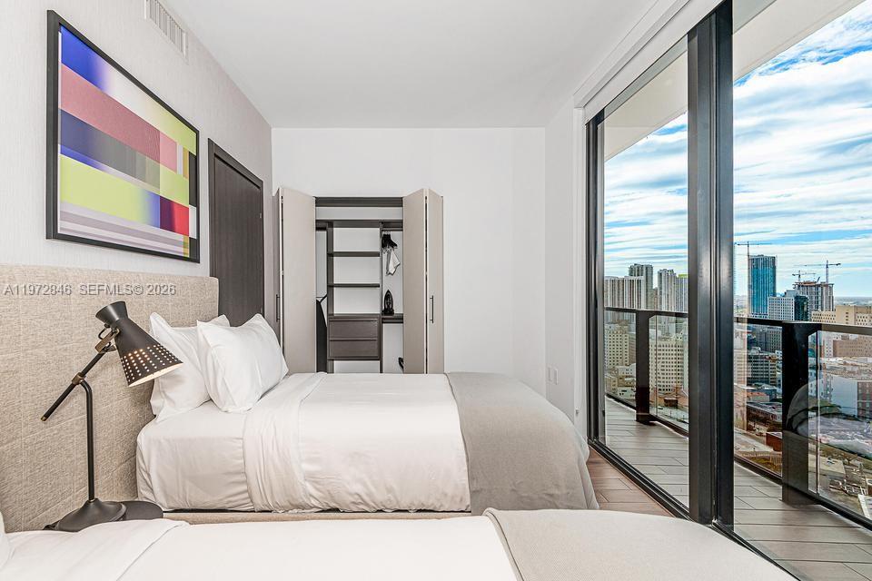 398 Northeast 5th Street, Unit 2418 Miami, FL 33132 - Photo 21 of 34 a bedroom with a large bed and a painting on the wall