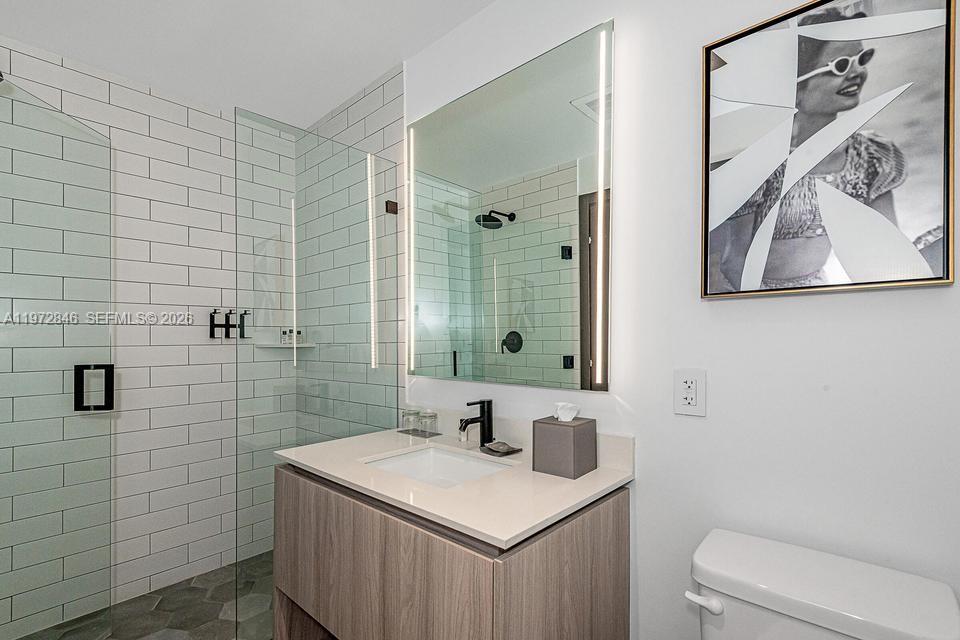 398 Northeast 5th Street, Unit 2418 Miami, FL 33132 - Photo 26 of 34 a bathroom with a sink a toilet and mirror