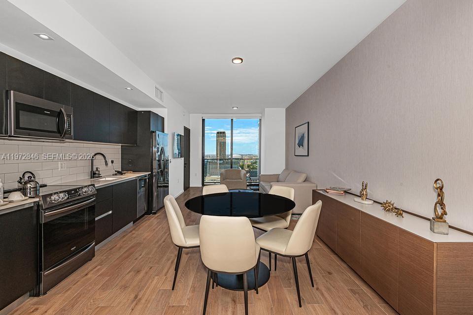 398 Northeast 5th Street, Unit 2418 Miami, FL 33132 - Photo 3 of 34 a kitchen with a table chairs a sink and appliances