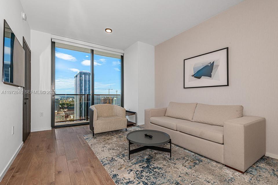 398 Northeast 5th Street, Unit 2418 Miami, FL 33132 - Photo 6 of 34 a living room with furniture and a large window