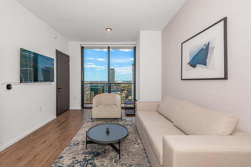 398 Northeast 5th Street, Unit 2418 Miami, FL 33132 - Photo 7 of 34 a living room with furniture and wooden floor