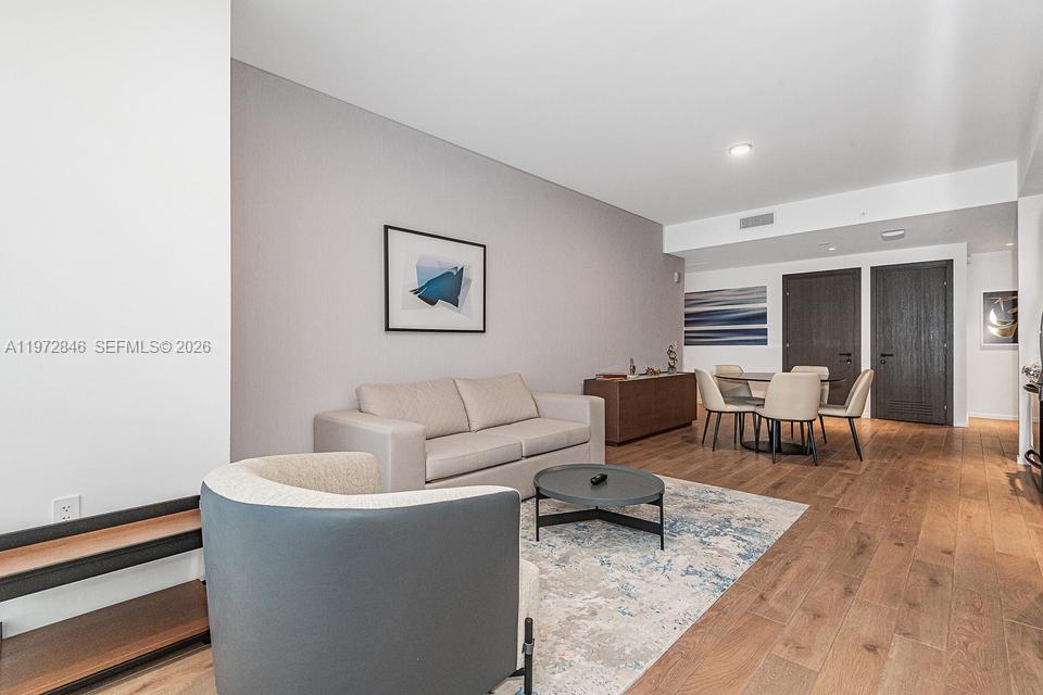 398 Northeast 5th Street, Unit 2418 Miami, FL 33132 - Photo 8 of 34 a living room with furniture and a lamp