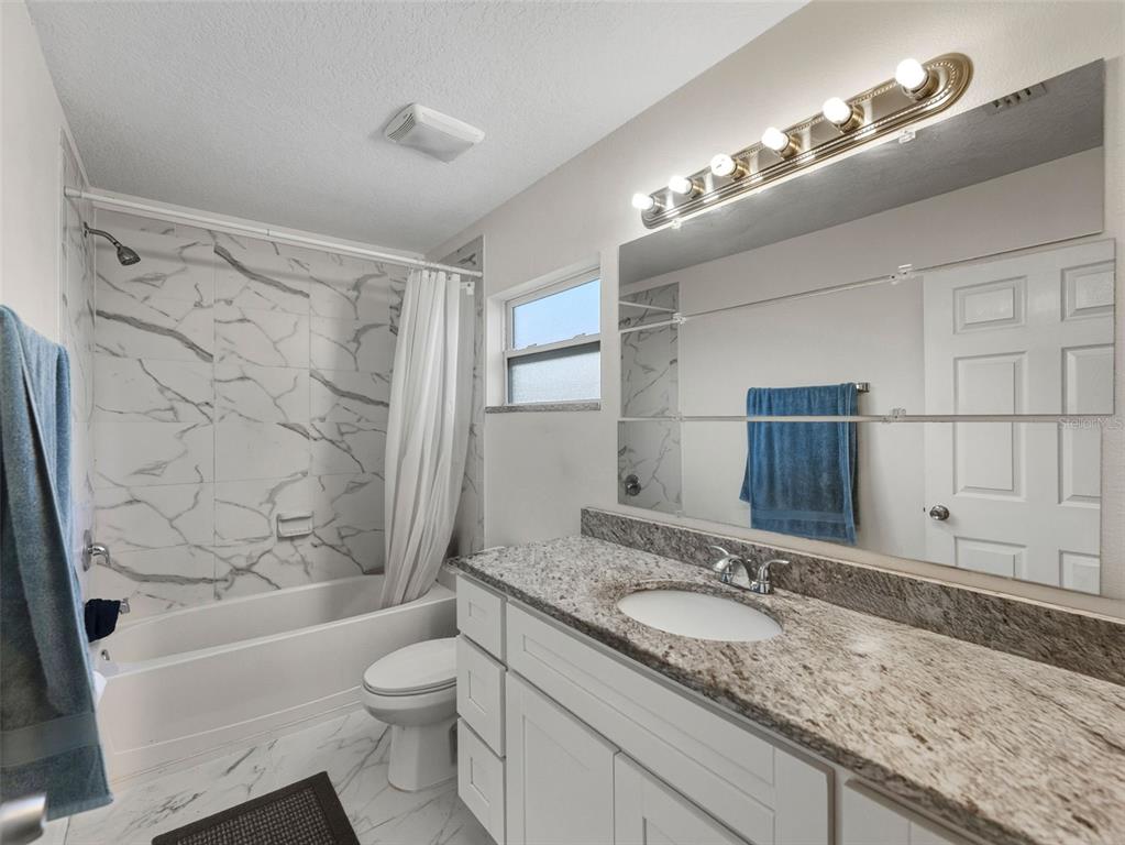 5104 Timberlan Street Tampa, FL 33624 - Photo 15 of 27 a bathroom with a granite countertop sink toilet and shower