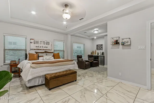 a bedroom with a large bed and a flat tv screen on dresser