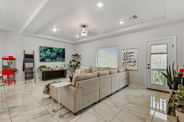 a living room with furniture kitchen view and a chandelier