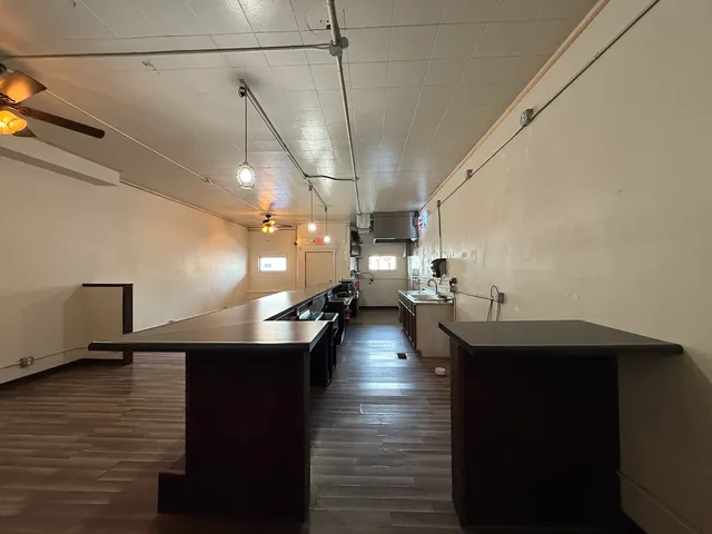 a kitchen with lots of counter space and view of living room