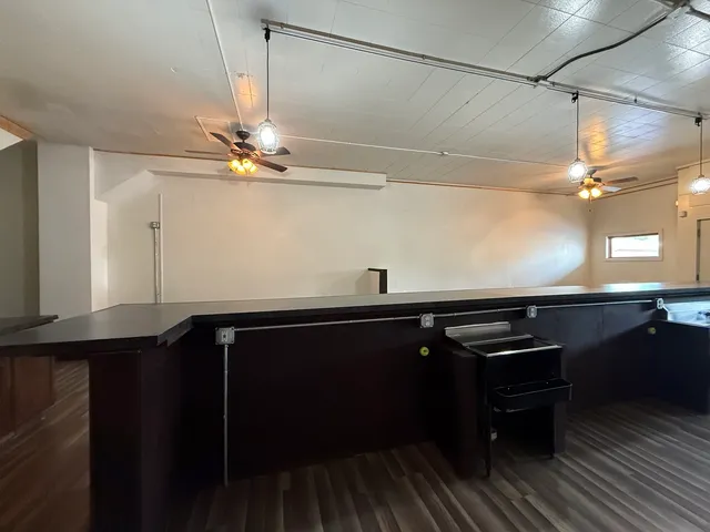 a kitchen with a sink cabinets and wooden floor