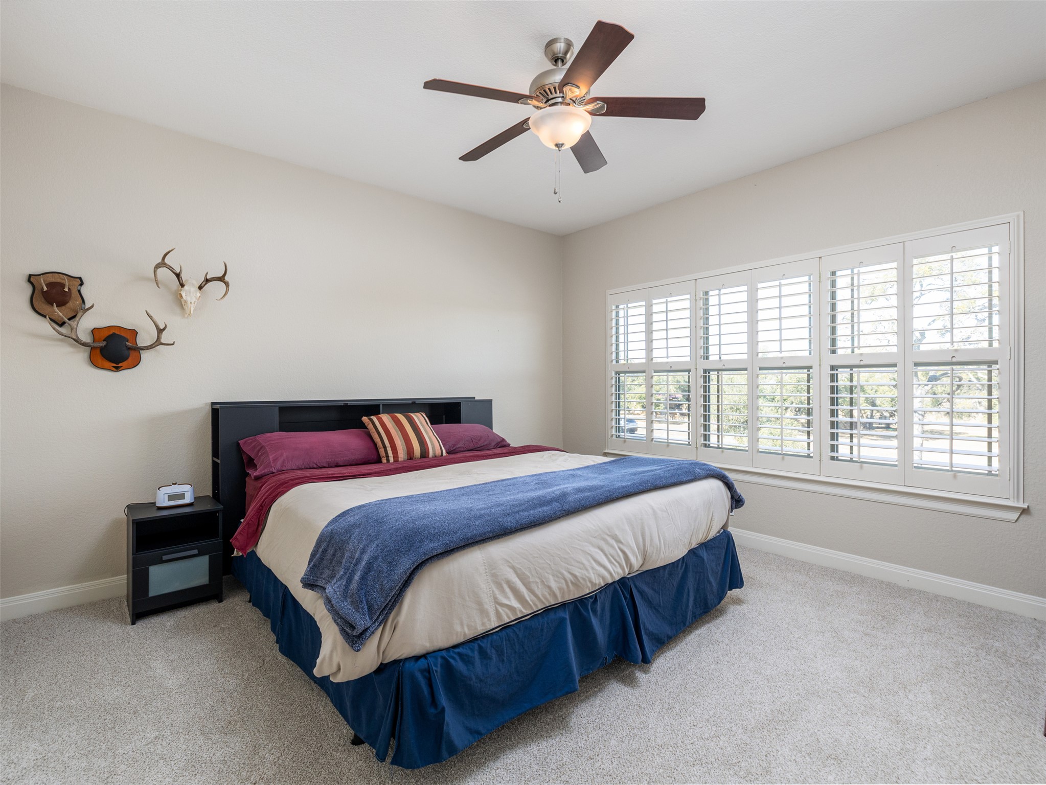 1316 Ranchers Club Lane Driftwood, TX 78619 - Photo 24 of 40 a spacious bedroom with a bed and a chandelier