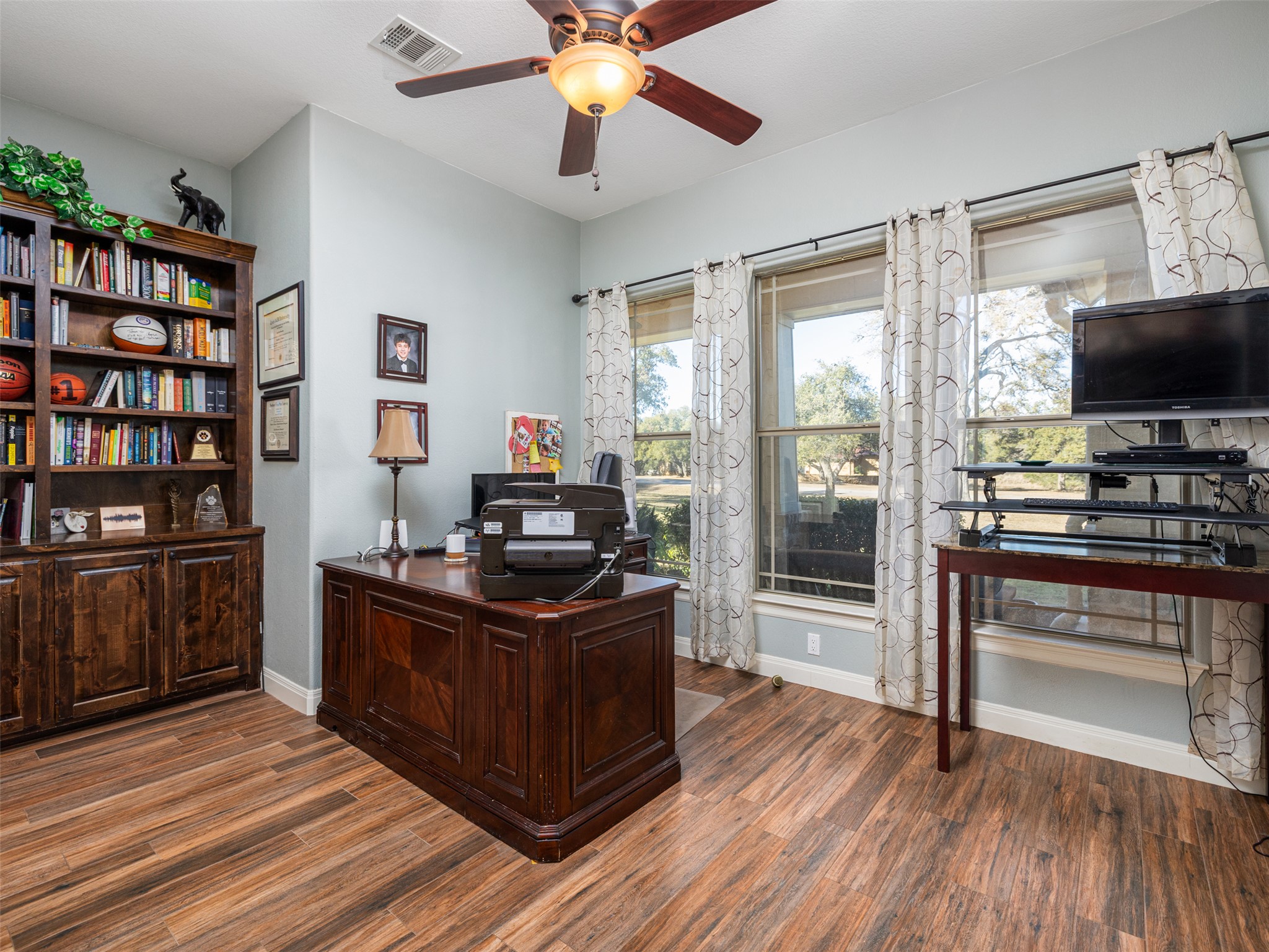 1316 Ranchers Club Lane Driftwood, TX 78619 - Photo 29 of 40 a view of a workspace with furniture and a flat screen tv