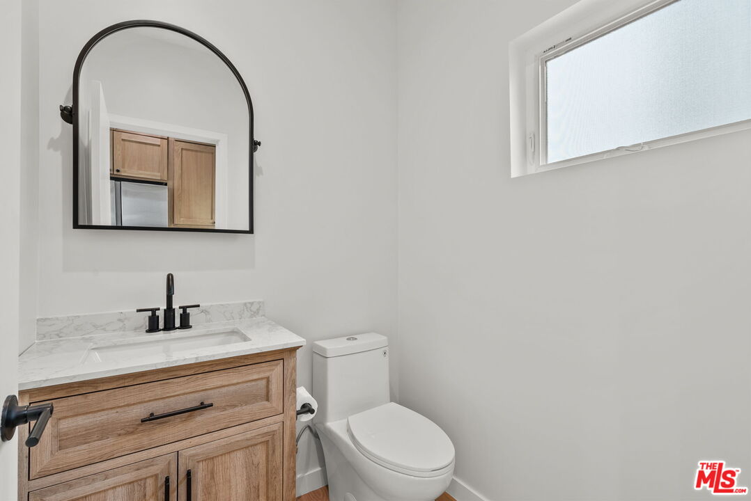 128 South Swall Drive, Unit 1/2 Los Angeles, CA 90048 - Photo 11 of 32 a bathroom with a toilet sink and mirror